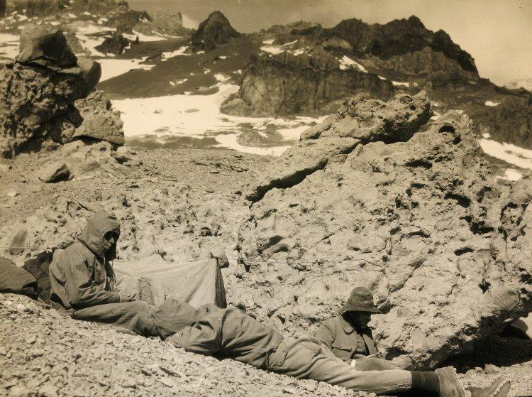 A couple of men sitting on a rocky surface

AI-generated content may be incorrect.